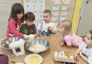 Dziewczynka wsypuje mąkę do miski