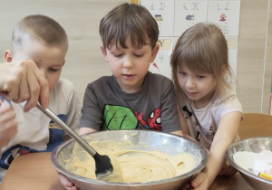 Dzieci mieszają składniki na babeczki