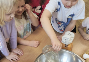 Chłopiec wsypuje cukier do miski