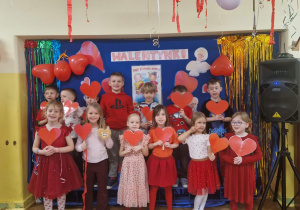 Dzieci z gr 4 pozują do zdjęcia z czerwonymi serduszkami