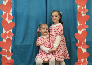 Dziewczynki pozują do zdjęcia w walentynkowej ramce