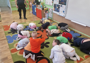 Dzieci ćwiczą pozycję bezpieczną żółwia