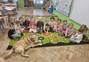 Dzieci z 1 gr pozują doa zdjęcia z psem