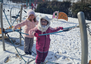 dwie dziewczynki przechodzą po drabinie
