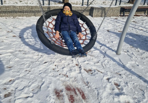 chłopiec huśta się na bocianim gnieździe