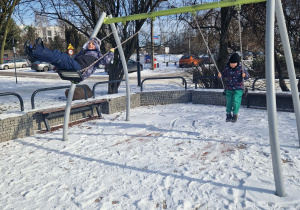 dzieci huśtają się na huśtawce