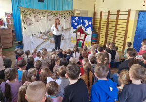 Aktorka z teatru wita zgromadzona na sali dzieci