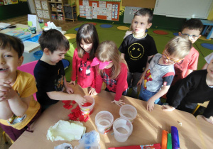 Dziecko wrzuca bibułę do słoika