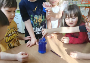 Dziecko wrzuca bibułę do słoika