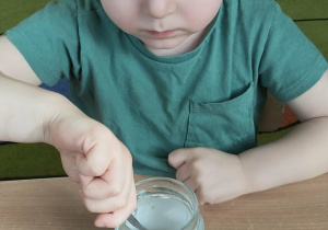 Dziecko miesza sól z wodą