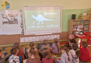 Dzieci oglądają film edukacyjny o dinozaurach