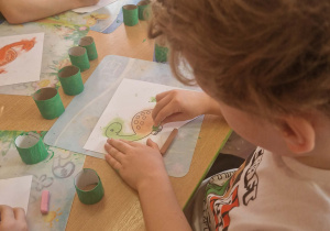 Dzieci koloruja suchą pastelą dinozaura