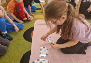 Dziewczynka układa jaja dinozaura w/g kolejności