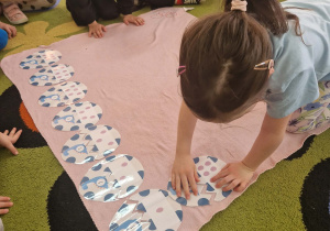 Dziewczynka układa jaja dinozaura w/g kolejności