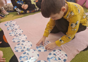 Chłopiec układa jaja dinozaura w/g kolejności