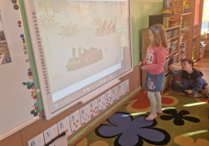 Dzieci wykonują zadanie na tablicy interaktywnej