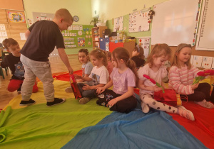 Chłopiec wręcza prezent koleżance z okazji Dnia Kobiet