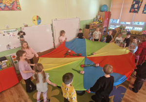 Dzieci unoszą delikatnie balonowe kwiatki na chuście