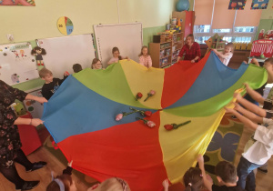 Dzieci unoszą delikatnie balonowe kwiatki na chuście