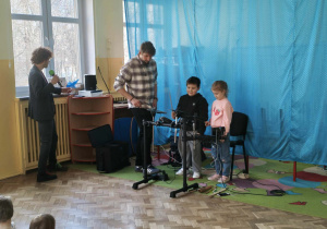 Dwoje dzieci podejmuje próby grania na perkusji