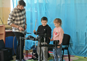 Dwoje dzieci podejmuje próby grania na perkusji