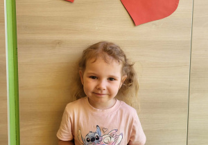 Dziewczynka stoi z medalem super dziewczynka