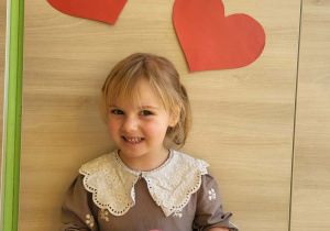 Dziewczynka stoi z medalem super dziewczynka