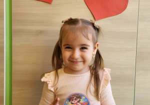 Dziewczynka stoi z medalem super dziewczynka