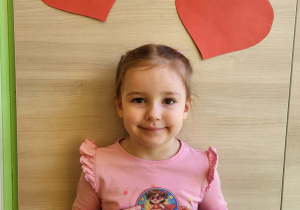 Dziewczynka stoi z medalem super dziewczynka