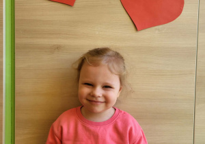 Dziewczynka stoi z medalem super dziewczynka