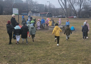 Dzieci w rękawiczkach zbieraja śmieci do worka