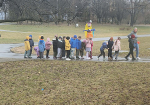 Dzieci spacerują po parku z Marzanną