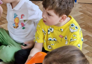 Dzieci przekazują sobie pomarańczowy krążek