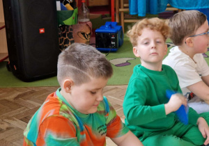 Dzieci uczestniczą w zabawie z kolorowymi krążkami