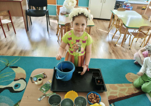 Dziewczynka nasypuje ziemię do doniczki