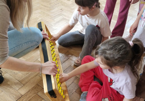 dzieci manipuluja na dużym liczydle liczydle