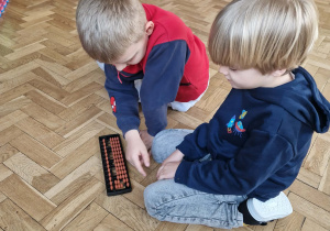 dzieci manipulują na małym liczydle