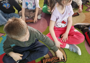 dzieci manipulują na małym liczydle