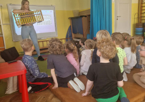 Pani przedstawia dziciom loczydło