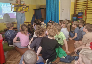 Pani przedstawia dziciom loczydło