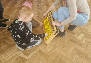 dzieci manipuluja na dużym liczydle liczydle