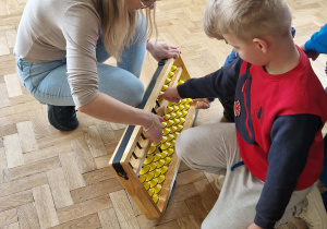 dzieci manipuluja na dużym liczydle liczydle