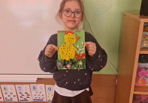 dziewczynka prezentuje konkursową pracę plastyczną