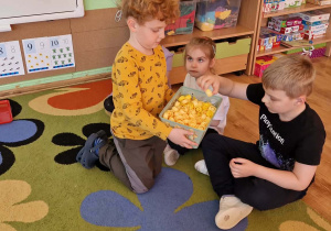 chłopiec rozdaje korki do głosowania