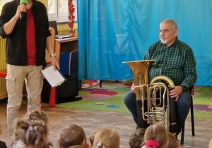 Pan prezentuje dzieciom tubę