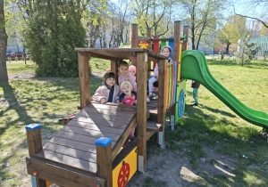 dzieci bawią się na urządzeniach terenowych