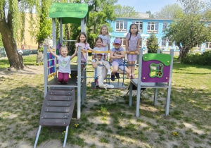 dzieci bawią się na urządzeniach terenowych