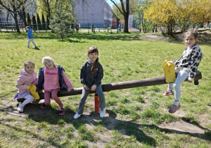 dzieci bawią się na urządzeniach terenowych