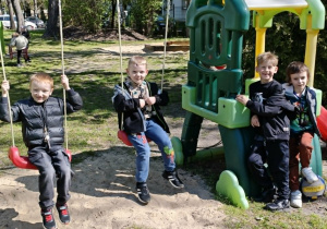 dzieci bawią się na urządzeniach terenowych