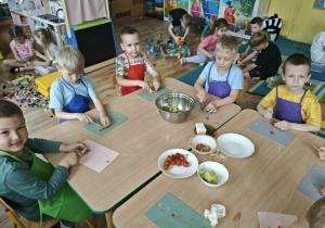 dzieci kroją warzywa na sałatkę